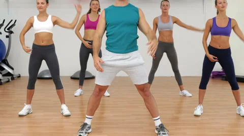 Aerobics class stretching together led by instructor Stock Footage 36899062