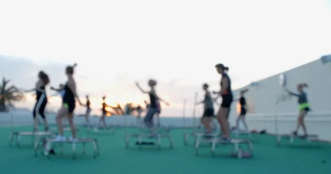 An Aerobics class using trampolines in the sun. Vídeo Stock 85538634
