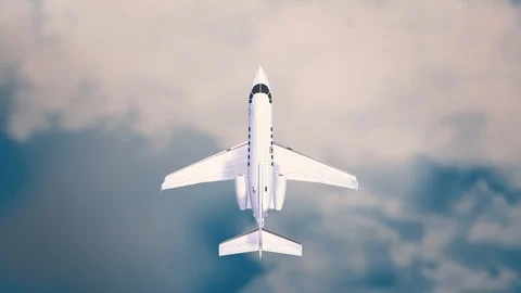 Aeroplane Flying Through Clouds in the blue sky through sunshine and clouds in Stock Footage 121802018