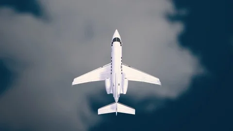 Aeroplane Flying Through Clouds in the blue sky through sunshine and clouds in Stock Footage 121802292