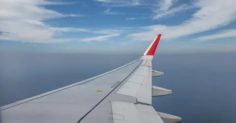 Aeroplane wing closeup view while in sky with clouds Stock Photos