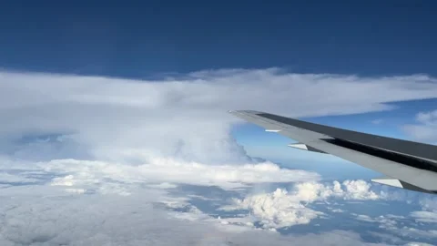 Aeroplane wing flaps lifting as plane flies through white storm clouds in sky Stock Footage 292950110