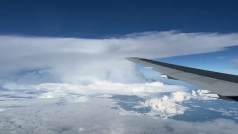 Aeroplane wing flying through bright white summer storm clouds Stock Footage 292950135