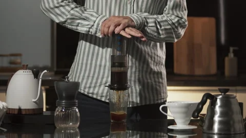 Aeropress coffee: barista press to device and coffee drops pours trought Stock Footage