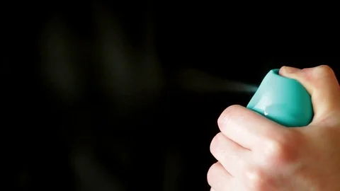 Aerosol can being sprayed against a black background Stock Footage 73349500