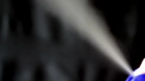 Aerosol can being sprayed against a black background Stock Footage 73349554