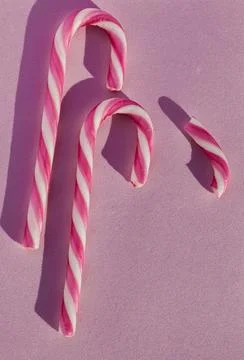 Aesthetic composition of two candy canes on a pink background. Stock Photos