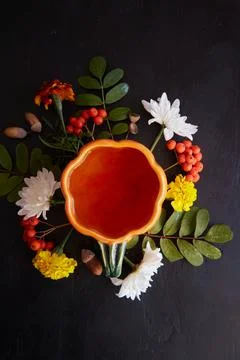 Aesthetic creative cup in shape of pumpkin of herbal tea among rowan berries Stock Photos