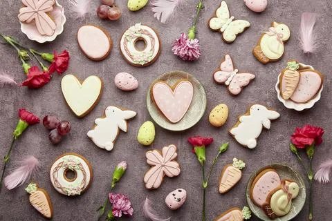Aesthetic Happy Easter background. Easter glazed cookies, aster flowers, grapes Stock Photos