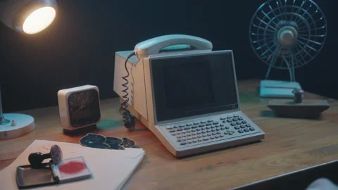 Aesthetic retro computer setup featuring a vintage phone and clock on a desk Stock Footage 327386795