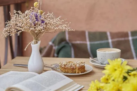 Aesthetic table setting - coffee, dessert. Cutting doughnut with cappuccino Stock Photos