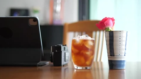 Aesthetic workspace with iced coffee, tablet, vintage camera, and pink rose 스톡 동영상 332421925