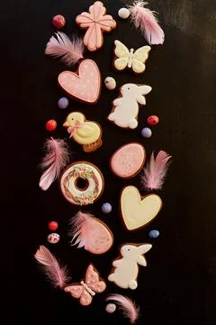 Aesthetics springtime Easter glazed cookies decorated feathers on black Stock Photos
