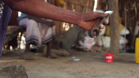 Afar man with sharpens knife to break child teeth, Afambo, Ethiopia Stock Footage 194789012