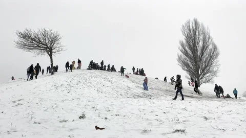 From afar view. Crowd of people  having fun In cold winter day Stock Footage 148425075