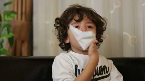 Affected by cold boy wipes his nose with handkerchief and sneezes Stock Footage 44341140
