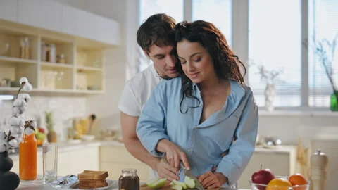 Affectionate couple cooking kitchen hugging laughing together at morning closeup Vidéo 253446276
