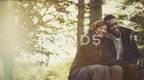 Affectionate couple hugging and drinking beer in woods Stock Photos