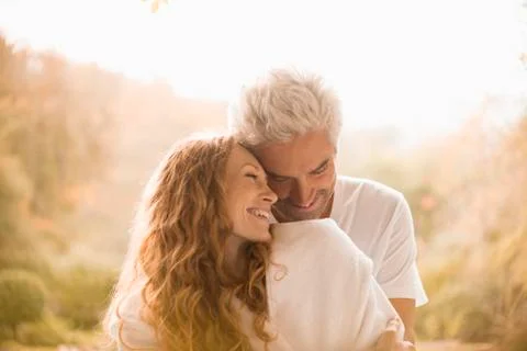 Affectionate couple hugging and smiling Stock Photos