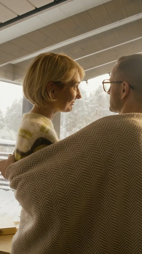 Affectionate Couple Hugging near Window in Cozy Winter Cabin Stock Footage 341306224
