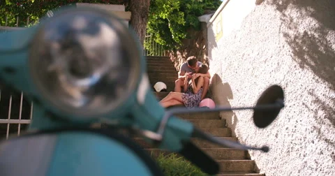 Affectionate couple sitting together on steps on a romantic getaway Video stock 48432619