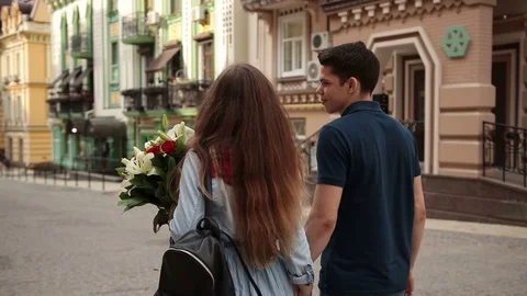 Affectionate couple walking down old city street Stock Footage 76109110