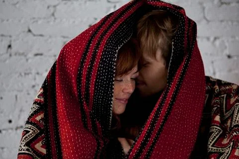 An affectionate couple wrapped in a blanket Stock Photos