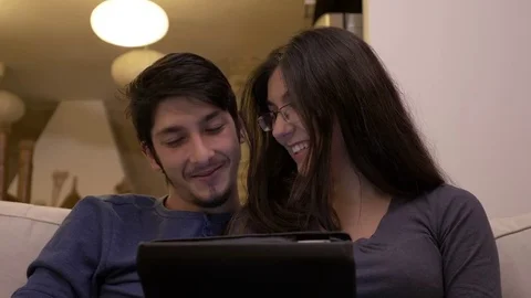 Affectionate happy couple watching video tutorials on tablet pc at home and d Stock Footage 83047199