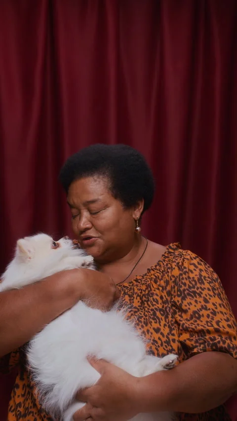 Affectionate Moment Between Senior Black Woman and Fluffy Dog in Photobooth Stock Footage 310741798
