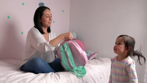Affectionate mother getting her child ready for her first day at school. Stock Footage 153718569