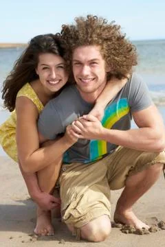 Affectionate young couple having fun on beach Stock Photos