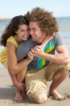 Affectionate young couple having fun on beach Stock Photos