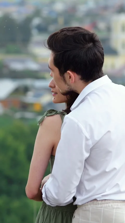 Affectionate young couple hugging from behind while standing on a hill Stock-Footage 341440441