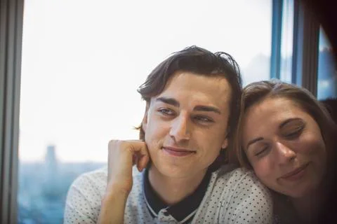 Affectionate young couple in window Stock Photos
