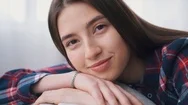 Affectionate Young Girl Relaxing On Back Of Sofa At Home Stock Footage