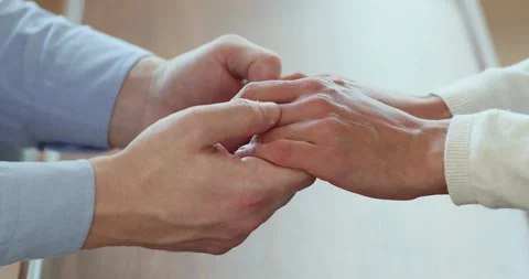 Affectionate young man holding hands of wife, showing support. 스톡 동영상 133142406