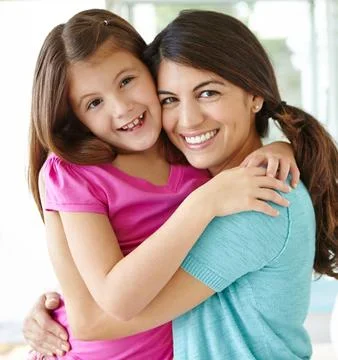 Affectionately hugging. Portrait of a pretty young mother spending time with her Stock Photos