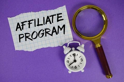 Affiliate Program text written on paper with magnifying glass and alarm clock Stock Photos