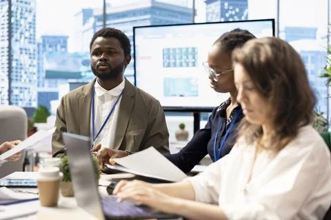 Affiliates collaborating in high end workspace to determine resource allocation Stock Photos