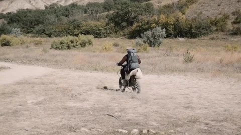 An Afghan with a backpack rides a mountain motorcycle to the mountains Stock Footage 202224648