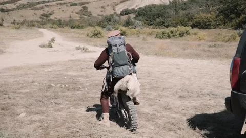 An Afghan with a backpack rides a mountain motorcycle to the mountains Stock Footage 202474998