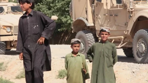 Afghan Children with MA-TV(MRAP) Mine Resistant Vehicles in background (HD)m Vidéo 7734014