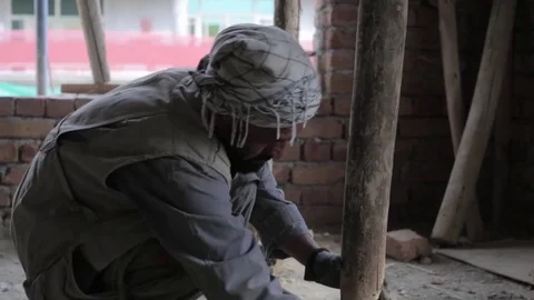 Afghan construction worker placing wood under support joist Stock Footage 91969986