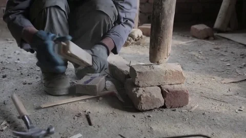 Afghan construction worker splitting wood for support joist Stock Footage 91970040