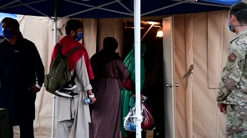 Afghan evacuees entering temporary accommodation tent at Ramstein Air Base, Germ Stock Footage 160106647