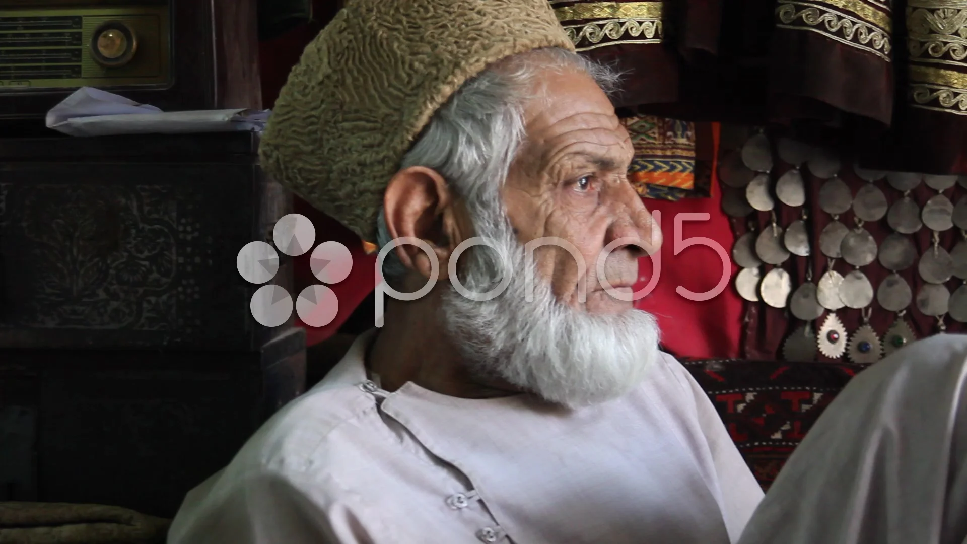 Afghan man watching TV in his shop