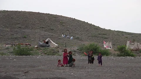 Afghan nomadic children in front of their tent Stock Footage 202257374