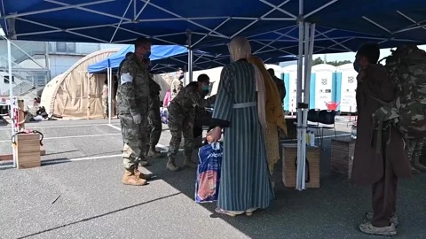 Afghan refugees queue to have temperature taken on arrival at Ramstein Air Base, Stock Footage 160106527