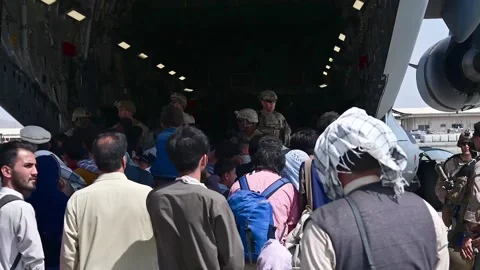 Afghan refugees queueing to board U.S. Air Force C-17 Globemaster at Hamid Karza Stock Footage 160106502