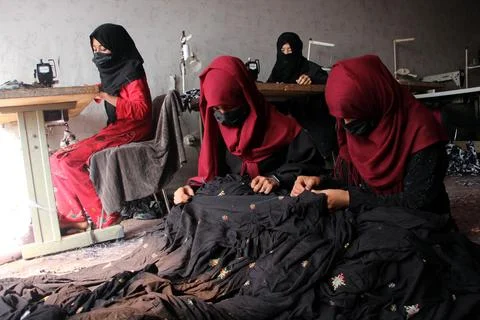 Afghan women work at a tailoring workshop on women's day in Kandahar, Afghanista Foto stock